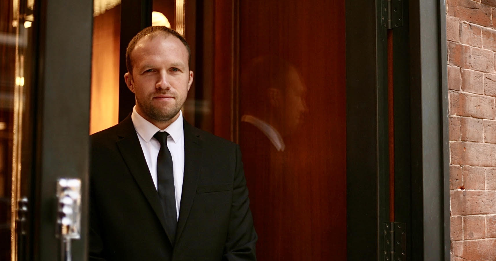 Security officer standing in the doorway of a business they are protecting