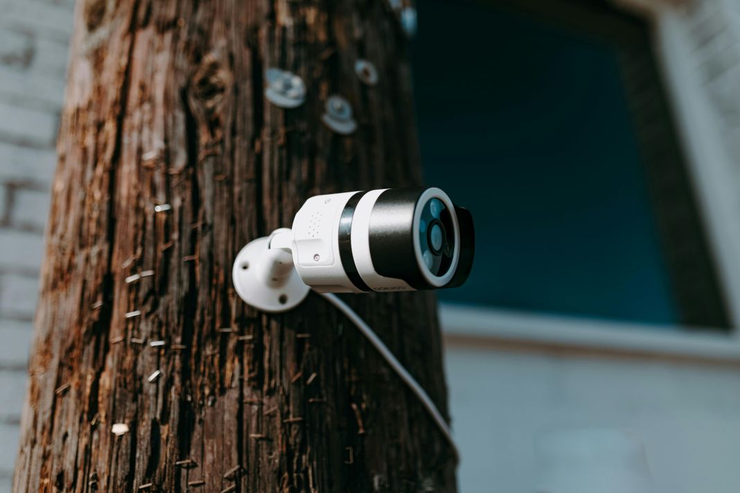 A bullet-style camera fixed to a wooden utility pole.