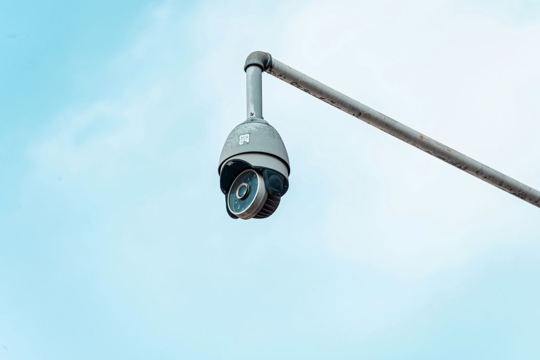 a photo of cctv in the sky connected to a pole