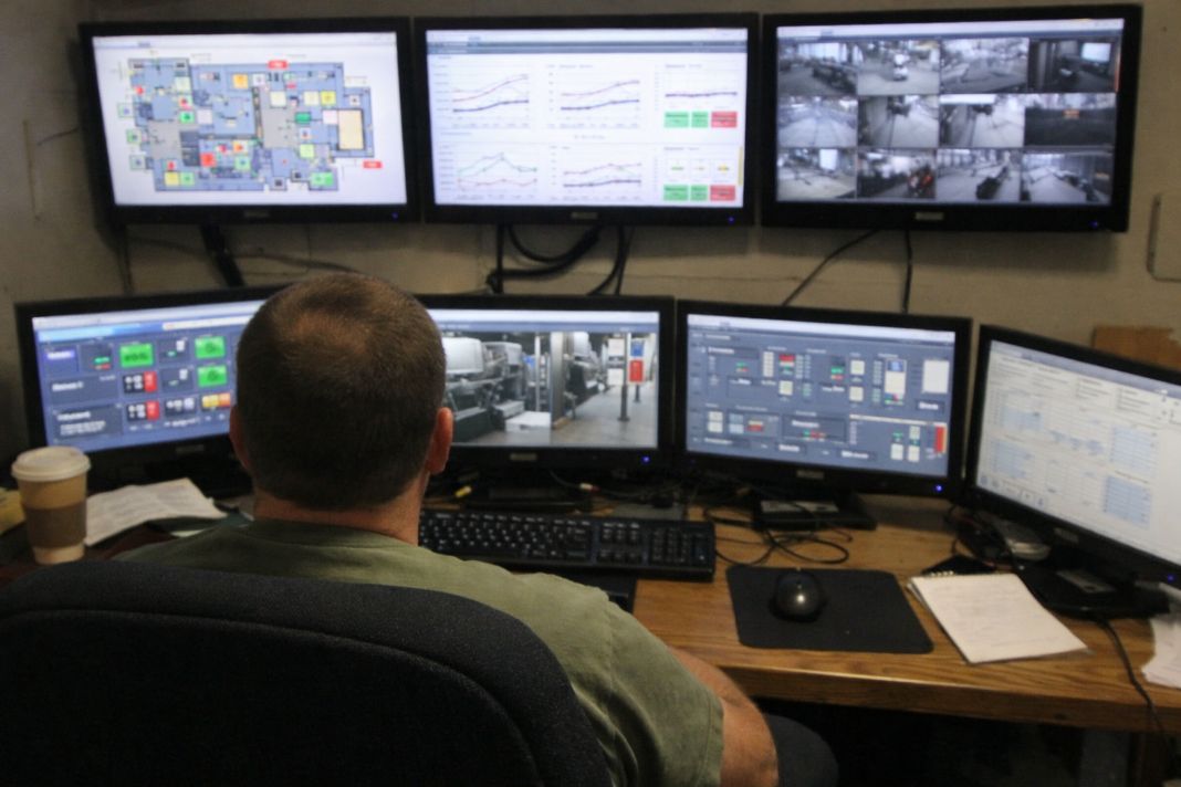A representative image of a control room with multiple facility monitoring screens showing building stats