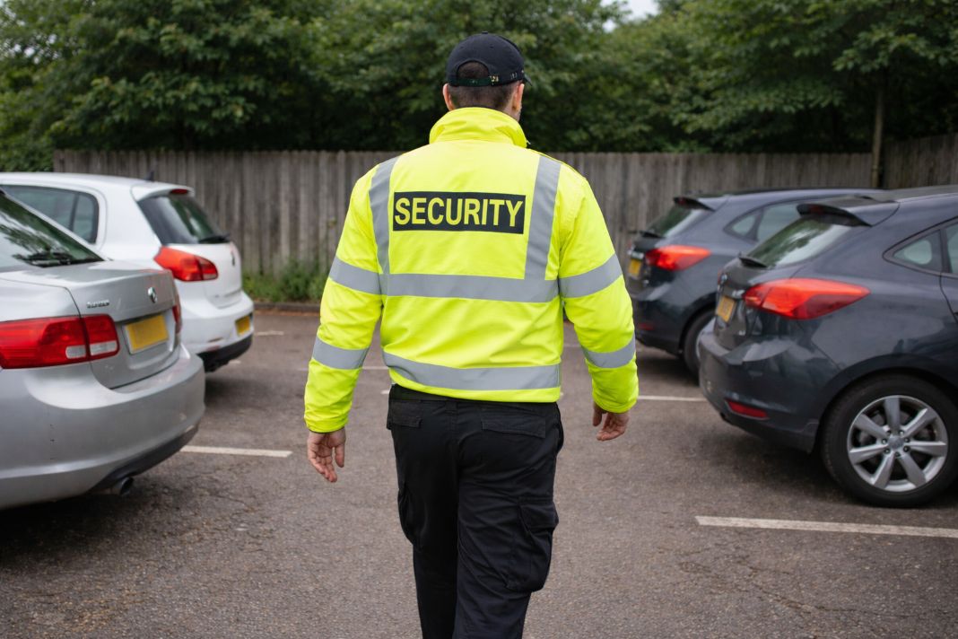 An illustrative image of security patrolling a small car park