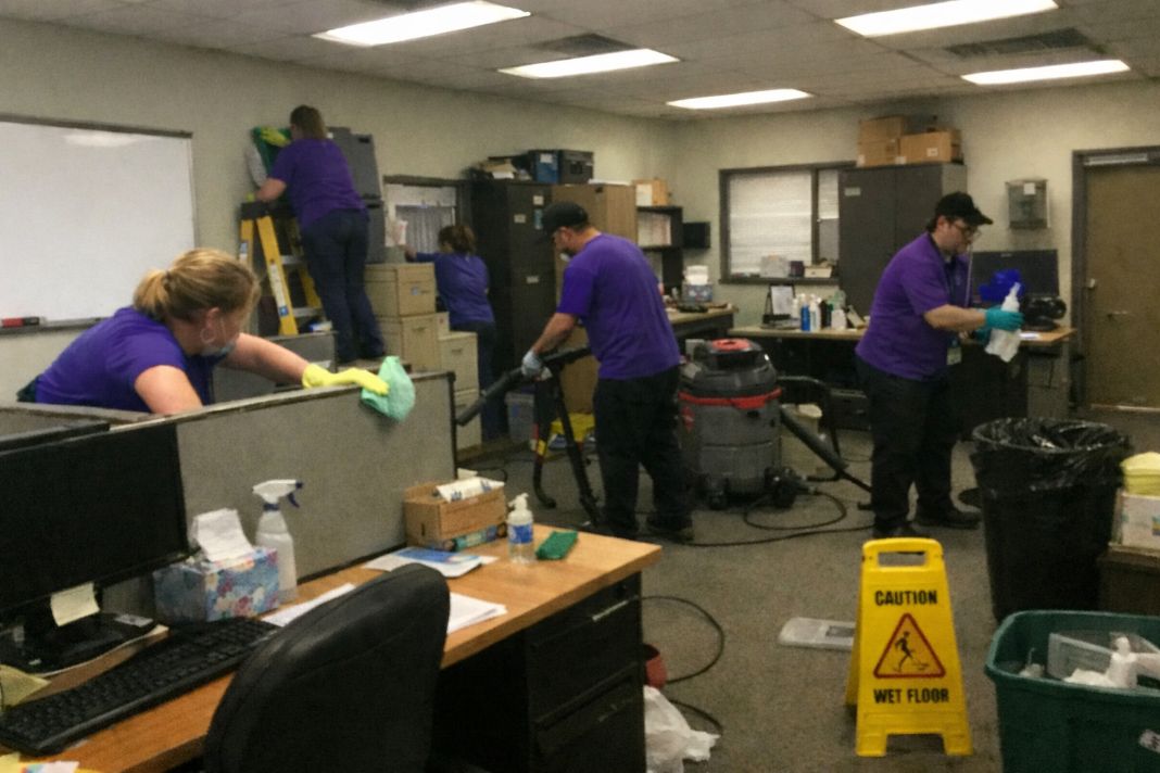 an ai photo of multiple cleaners cleaning an office doing a deep clean