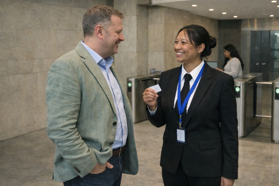 A representative image of a security officer assisting a building visitor at the entrance