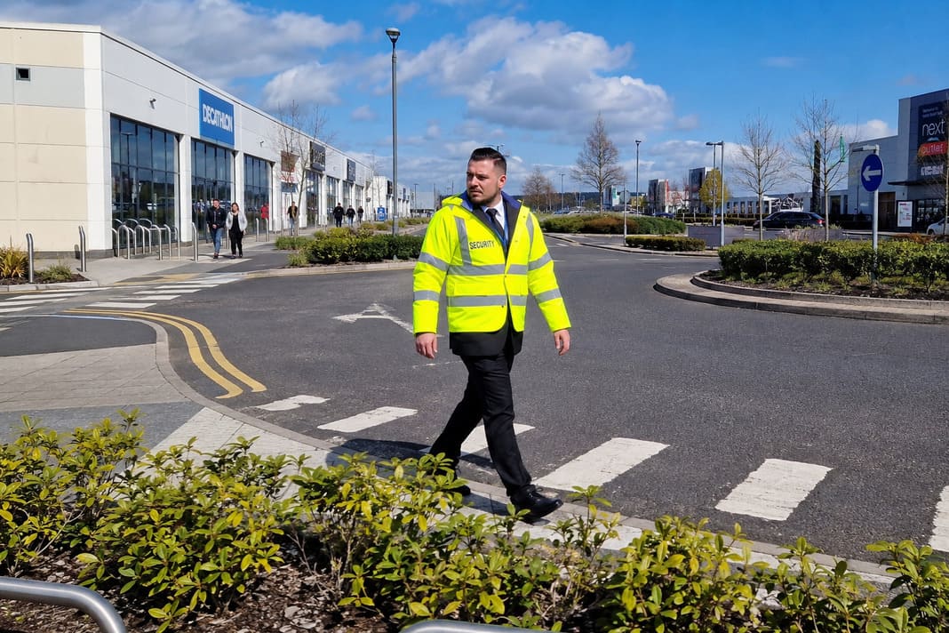 A photo of a security guard patrolling a retail park in the UK