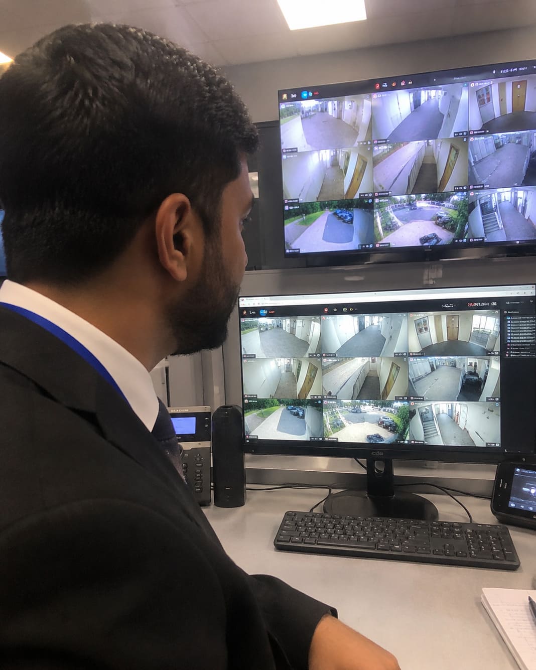 CCTV operator reviews warehouse camera feeds to verify alarms and activity remotely.