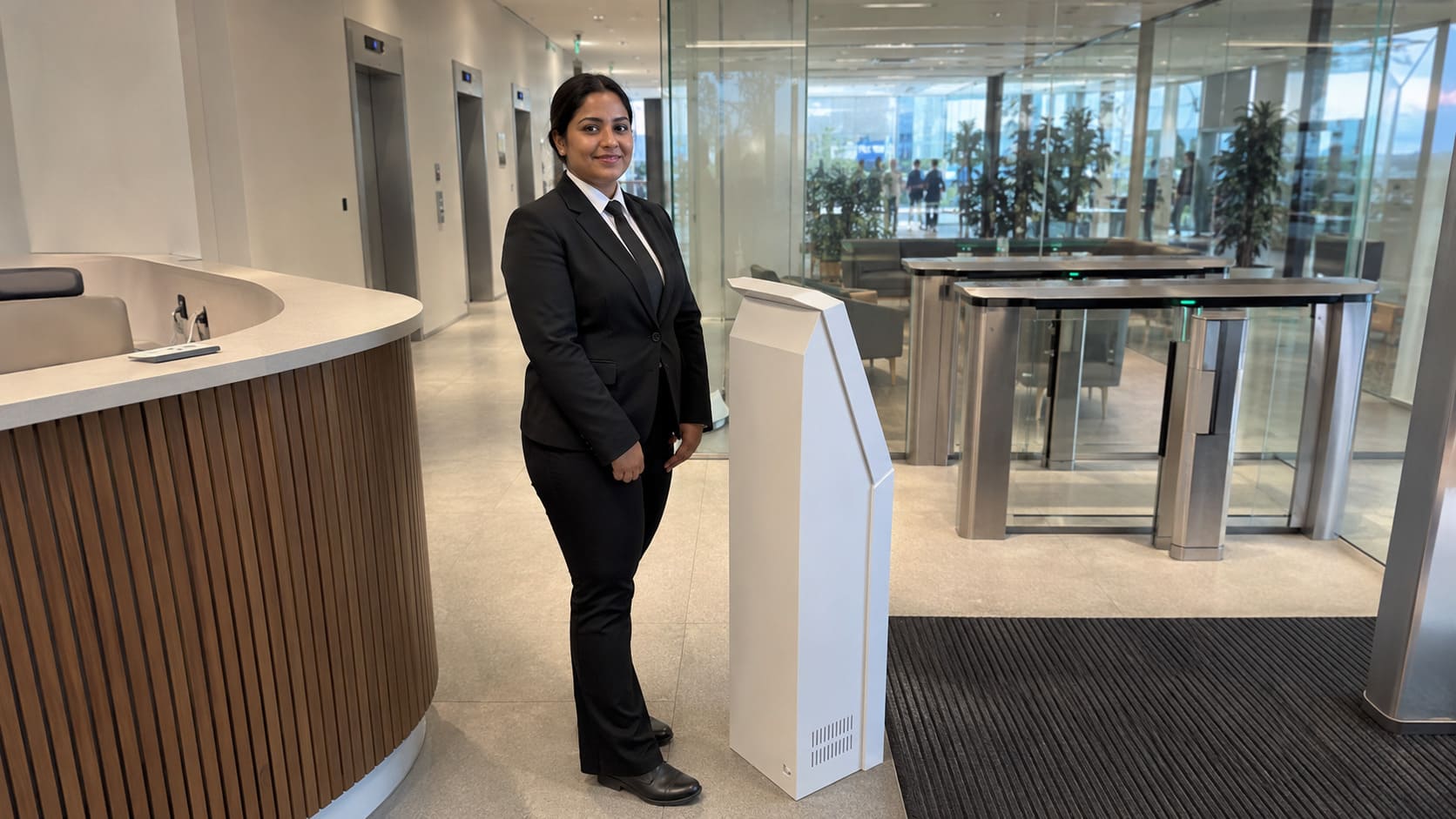 Corporate receptionist welcoming visitors at a modern front desk - Illustrative Image Corporate receptionist welcoming visitors at a modern front desk - Illustrative Image