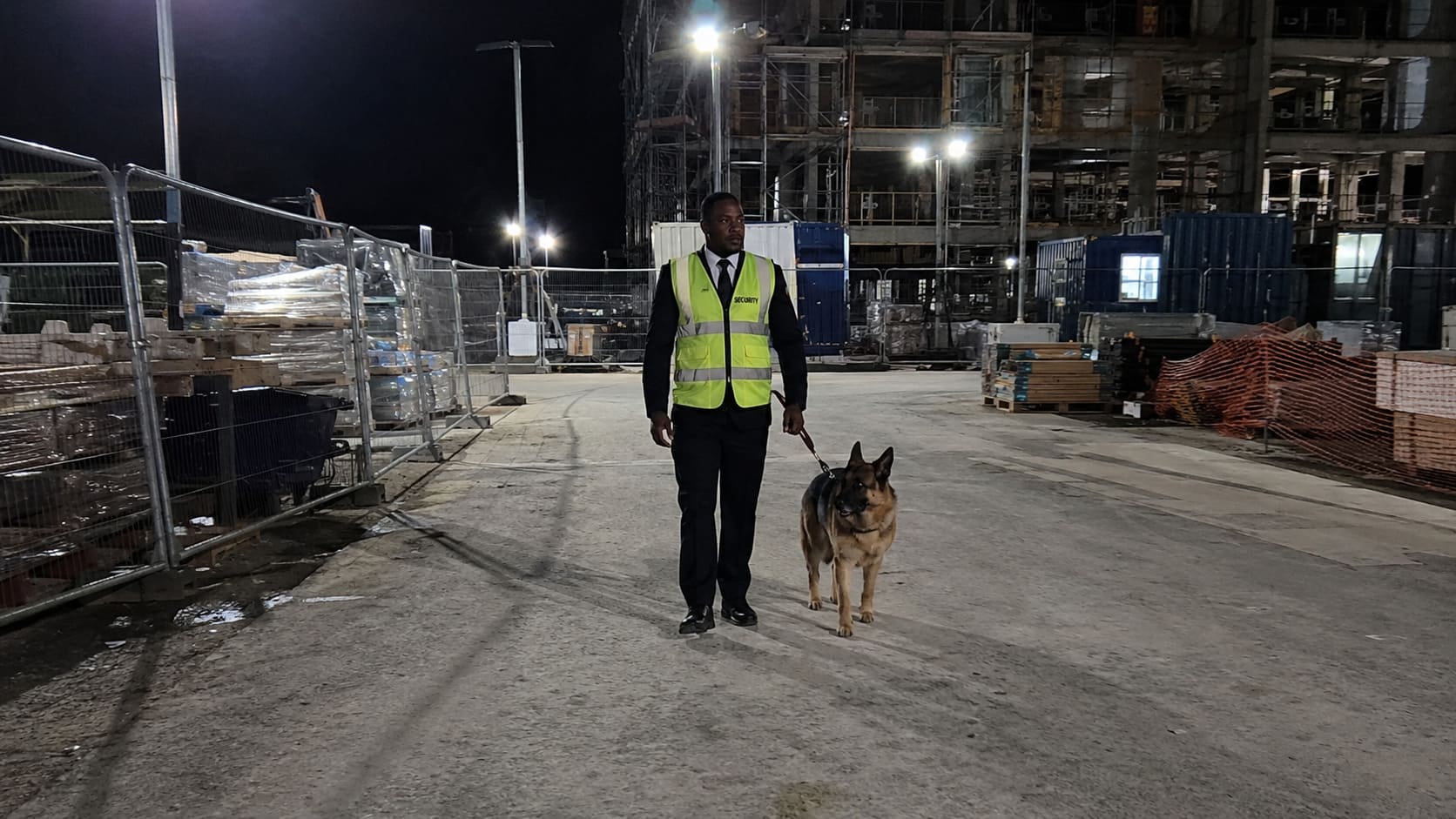 Security dog handler patrolling a construction storage yard - Illustrative Image