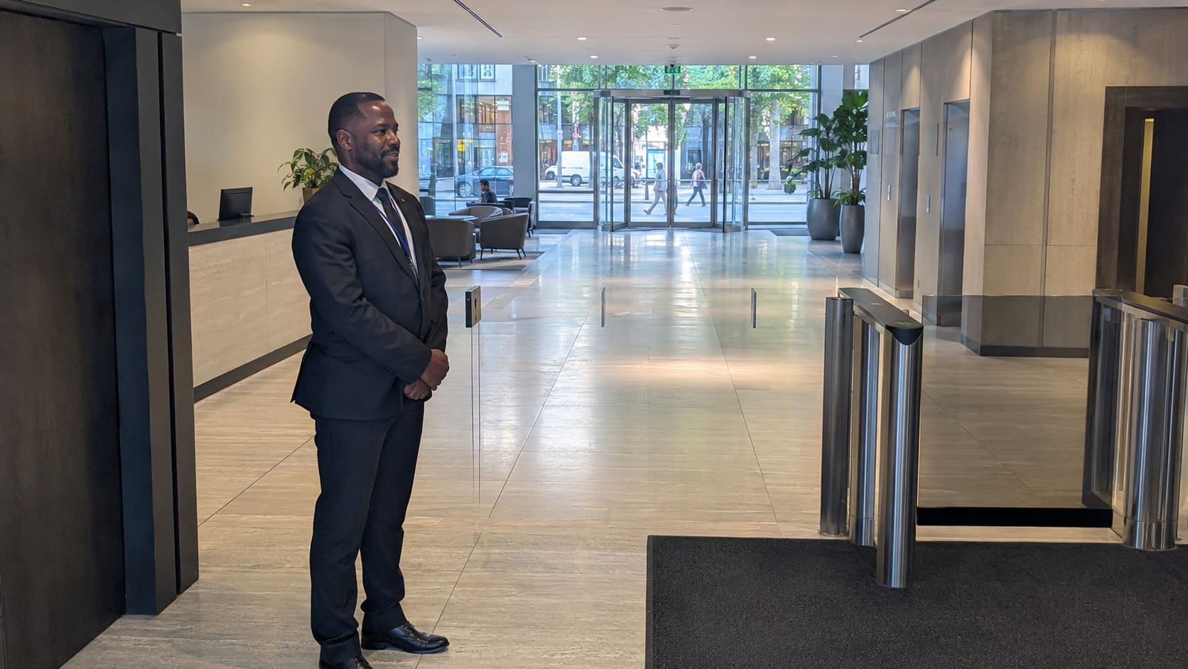 Security officer overseeing access gates in an office lobby - Illustrative Image Security officer overseeing access gates in an office lobby - Illustrative Image