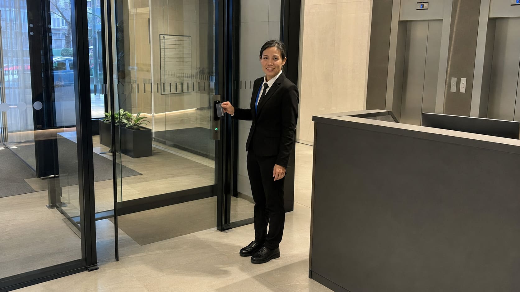 Suited security officer monitoring a commercial reception entrance - Illustrative Image