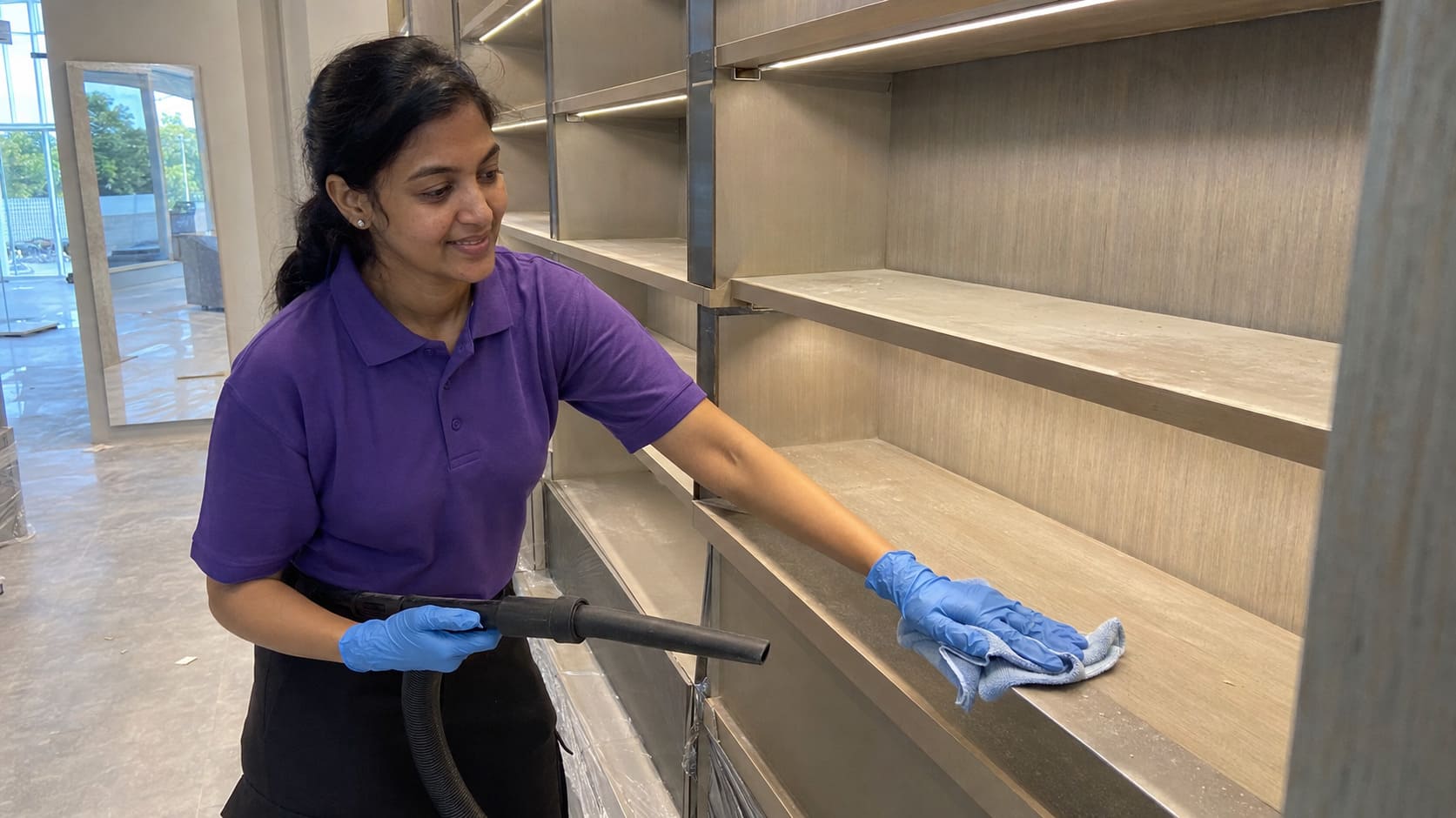 After builders cleaner removing construction dust from new retail shelving After builders cleaner removing construction dust from new retail shelving