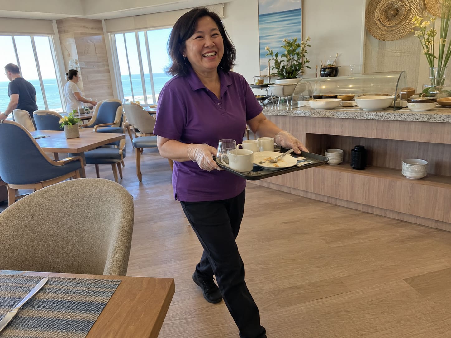 Café cleaner carrying supplies during routine hospitality cleaning