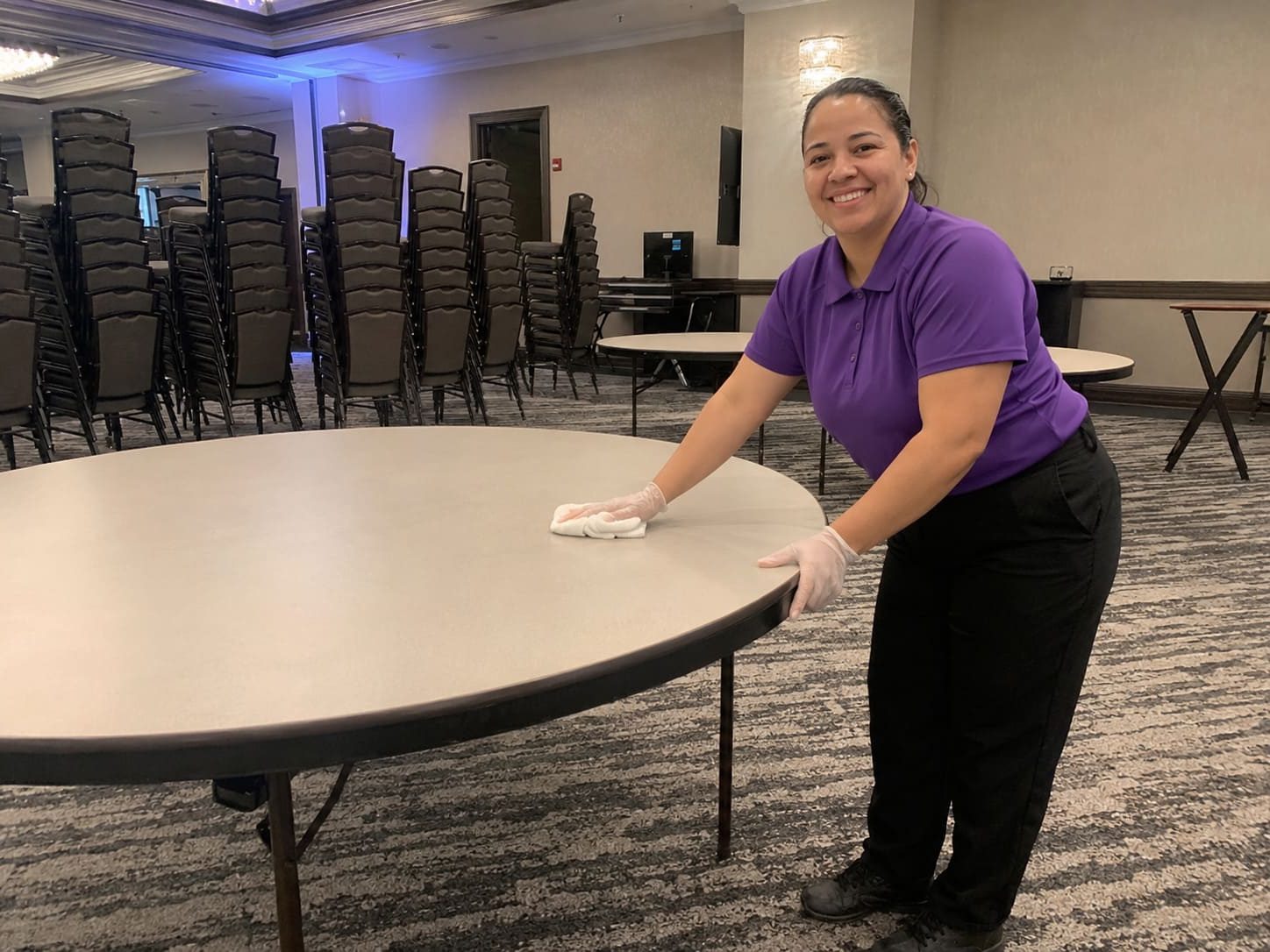 Event venue cleaner wiping large function room table