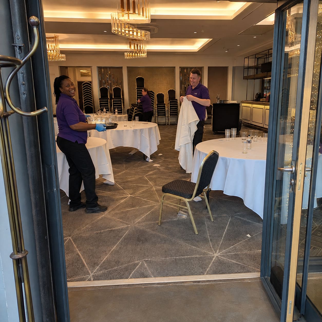 Event venue cleaners preparing function room after private gathering