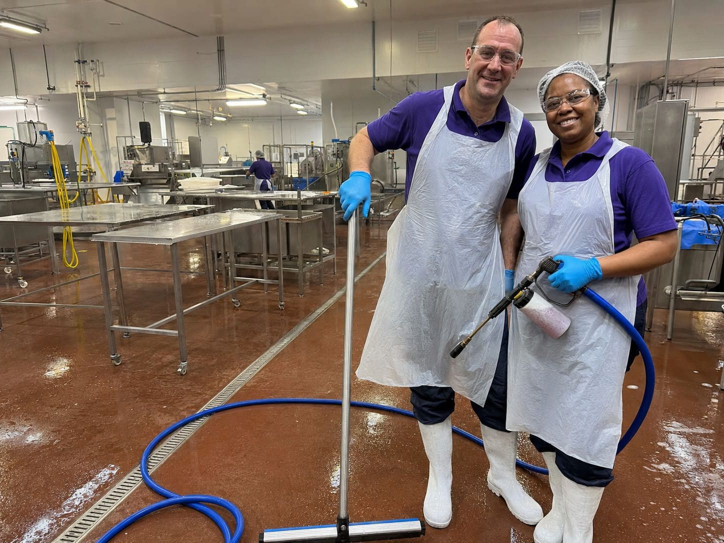 Food production cleaners washing hygienic processing room floors