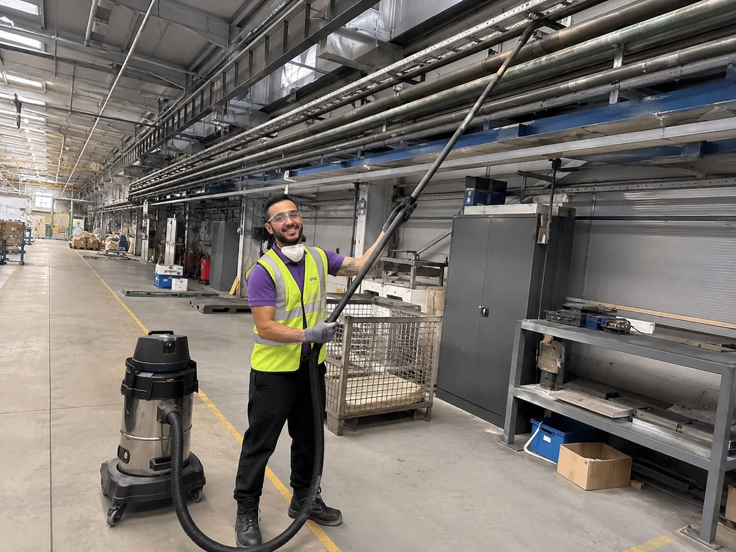 Industrial cleaner vacuuming factory floor during specialist cleaning - Illustrative Image